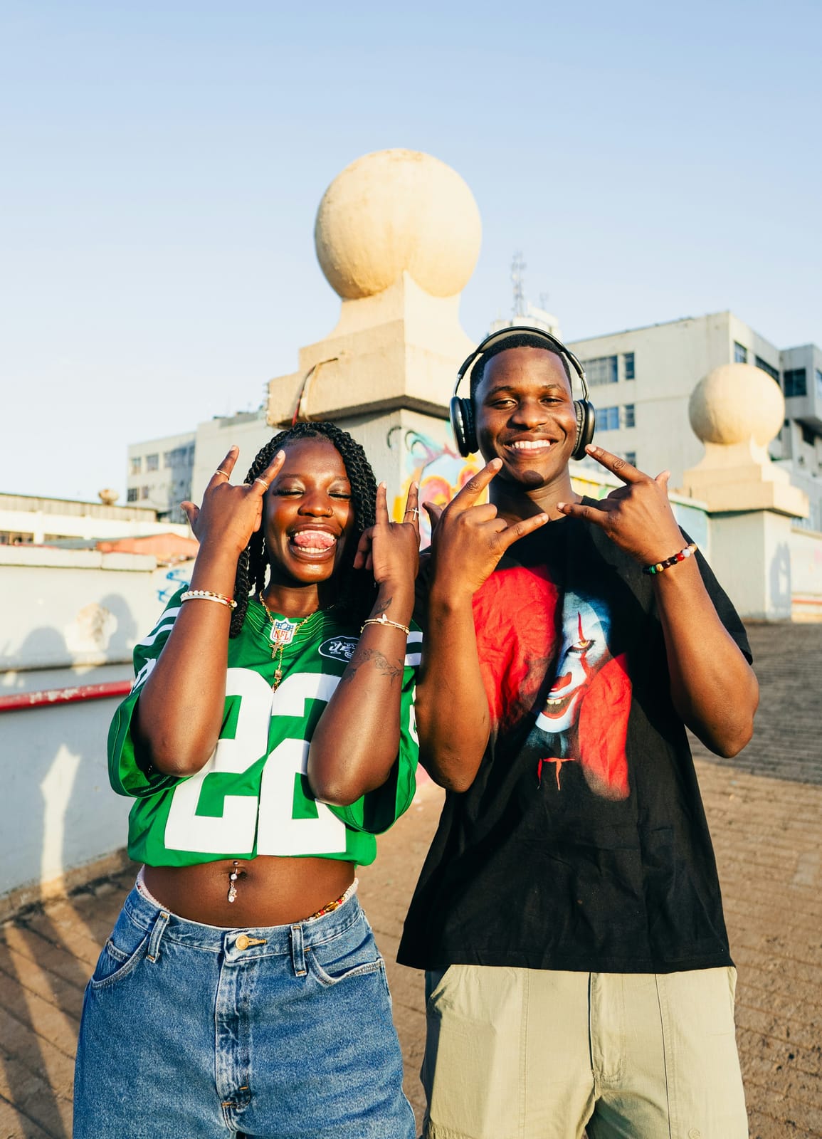 Two friends laughing and making rock-on signs.