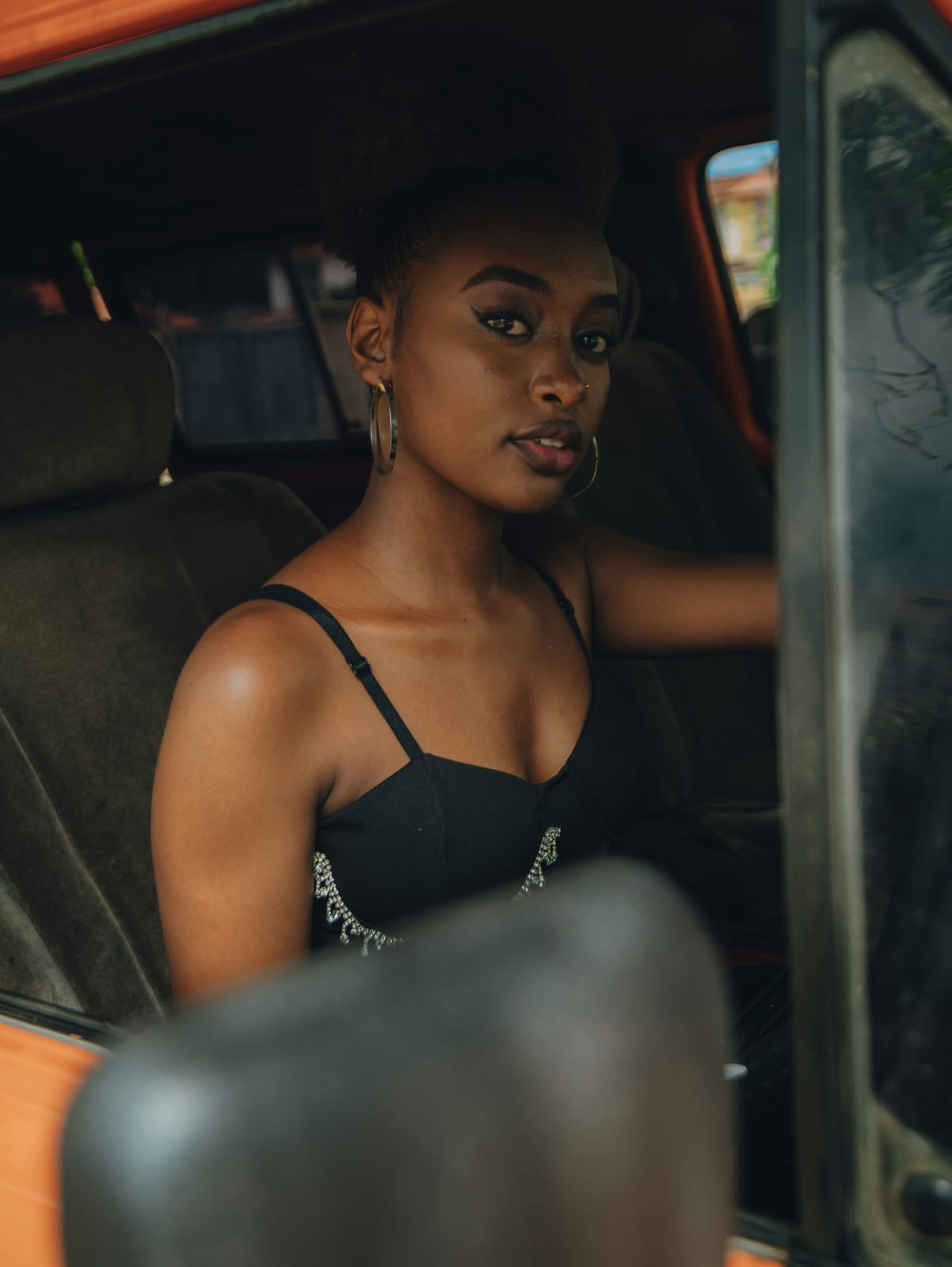 A young woman sitting in a car, ready to go.