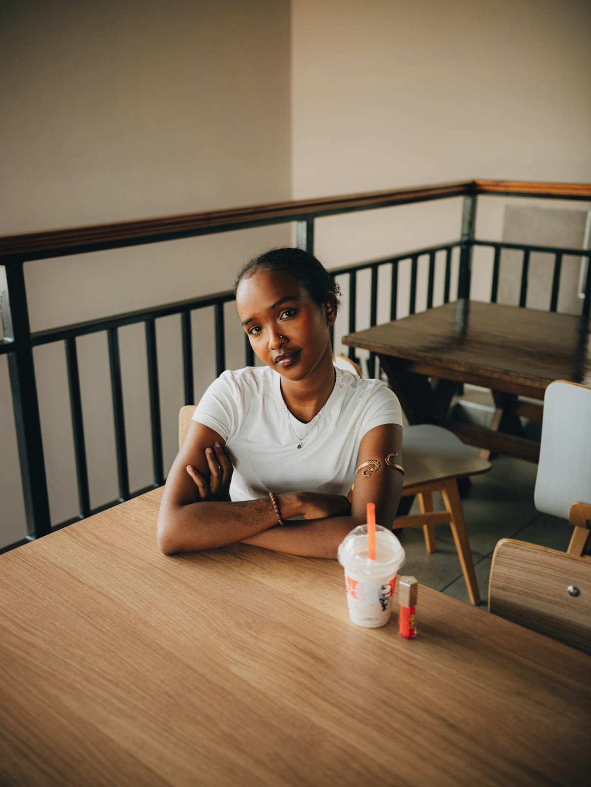 A young woman at a café table with a drink.